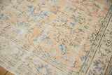 Distressed Oushak rug pile revealing apricot, ivory, and seafoam green scrolling vinery.