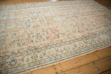 Distressed Oushak rug pile with faded apricot, ivory, and seafoam green floral motifs.