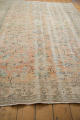 Distressed Oushak carpet edge with pale apricot and sand tones, showing wear.