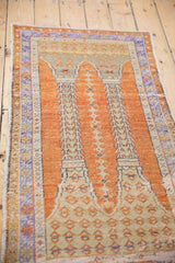 Distressed Oushak rug close-up: pale orange field, lavender border, worn texture, column design.