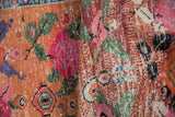 Detail of distressed Oushak rug: worn floral motifs, foundation visible, vibrant blush and tangerine.