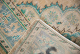 Distressed vintage Oushak rug corner revealing front pile and subtle blue-beige reverse foundation.