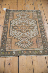 Corner of distressed vintage Oushak rug, highlighting geometric hook and latch motif.
