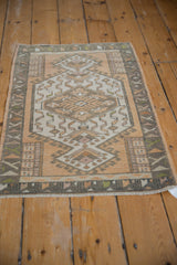 Distressed Oushak rug's muted geometric border with visible hook and latch motifs.