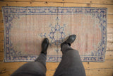 Distressed vintage Oushak rug runner with blush field and cobalt starburst pattern underfoot.
