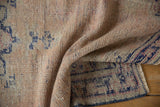 Vintage distressed Oushak rug's low pile texture in blush, ivory, and cobalt blue.