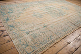 Distressed vintage Oushak carpet section showing worn beige pile, faded turquoise patterns, and visible selvage.