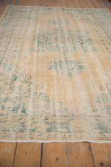 Distressed Oushak carpet texture featuring faded beige and denim blue colors with visible foundation.
