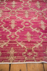 Heavily abrashed fuchsia pile with ivory germinating bud trellis on a vintage Oushak rug.