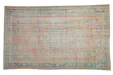 Faded vintage distressed Oushak rug, apricot, blush, pale denim blue, showing foundation wear.