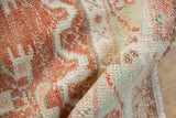 Distressed Oushak rug pile revealing cinnabar red, cream, and turquoise color pops.