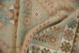 Detail of vintage distressed Oushak rug, revealing textured pile and even wear in soft beige and turquoise.