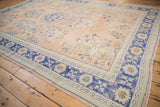 Distressed Oushak rug corner, worn apricot field, abrashed cobalt blue border with floral sprays.