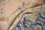 Distressed Oushak rug texture showing apricot, cobalt blue, and border abrashes.