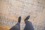 Distressed vintage Oushak rug with faded beige, blue, mint green floral bouquets and border.