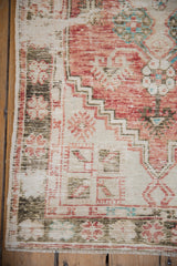 Distressed Oushak rug corner: stepped spandrel, playful floral border, and mostly even wear.