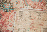 Close-up of vintage Oushak runner's hand-knotted reverse side and distressed floral pile.