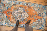 Distressed vintage Oushak rug, abrashed terra cotta, sapphire blue, ivory floral patterns, even wear.