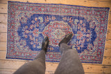 Distressed Vintage Oushak rug detail: cobalt blue, cherry red, ivory, and mostly even wear.