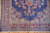 Distressed vintage Turkish Oushak rug corner, worn blue field, red border, and intact selvage.