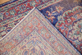 Oushak rug detail: worn cobalt blue, cherry red, ivory pile, visible foundation, plus selvage.
