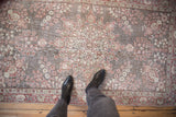 Distressed Sparta rug with oxidized silver and cherry red floral medallion, foundation showing through.