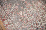 Faded cherry red and ivory floral motifs on distressed vintage Sparta rug, foundation showing.
