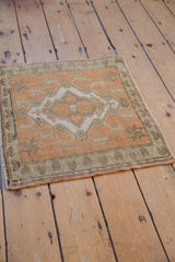 Distressed terracotta Oushak rug corner with ivory floral border and starburst motifs.