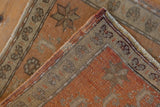 Distressed Oushak rug detail: hand-knotted foundation, intact side selvages, and worn terracotta pile.