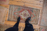 Vintage distressed Oushak rug with scalloped floral medallion in chestnut and oxidized silver.