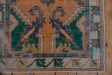 Distressed Vintage Oushak runner corner, revealing worn tangerine pile, deep green serrated leaves, and a primitively drawn border.