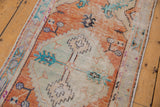 Distressed texture of vintage Oushak runner with tangerine orange and turquoise mint floral palmettes.