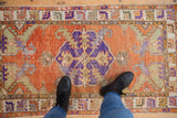 Vintage distressed Turkish Oushak rug, central violet medallion, abrashed burnt orange field.