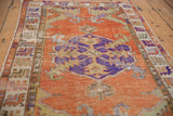 Distressed vintage Oushak rug border with violet and saffron geometric motifs.