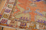 Distressed Turkish Oushak rug corner, saffron spandrel, violet, and ivory geometric border.