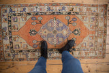 Distressed vintage Oushak rug runner with terracotta field and worn, pale blue motifs.
