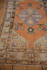 Textured distressed Oushak runner, terracotta pile, soft lavender medallion, ivory geometric border.