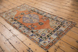 Distressed vintage Oushak runner corner, terracotta field and pale blue floral details.