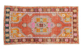 Distressed vintage Oushak rug runner with coppery-blush field and vibrant floral medallion.