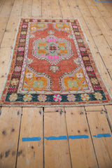 Distressed Oushak runner's corner, highlighting floral spandrel, ribboned borders, and fringe.
