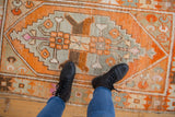 Time-softened tangerine, silver, and pink geometric patterns on a Vintage Distressed Oushak rug.