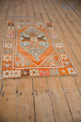 Vintage distressed Oushak rug corner with decorative geometric border in tangerine and beige.