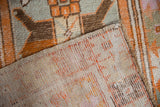 Distressed Oushak rug corner: geometric tangerine, oxidized silver pile, and hand-knotted reverse.