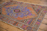 Distressed Oushak rug detail showing corner spandrel with geometric serpent motifs and bright pink.