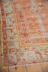 Distressed Oushak rug border showing faded brick red field and geometric patterns, with even wear.