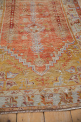 Faded saffron gold and ivory stepped mehrab motifs on a vintage distressed Oushak rug, showing even wear.