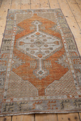 Terracotta, ivory, charcoal geometric motifs on distressed Oushak runner pile.