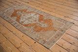 Distressed Oushak rug corner with secured side, terracotta and ivory lattice pattern.