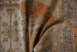 Distressed Oushak rug's secured side, displaying terracotta geometric patterns, short pile, and fringe.