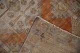 Distressed vintage Oushak rug, showing mostly even wear, terracotta, silver, and woven reverse.